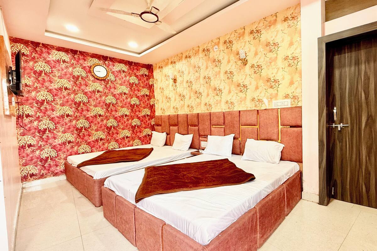 A double bed with a headboard, a clock on the wall, and a door to the right.