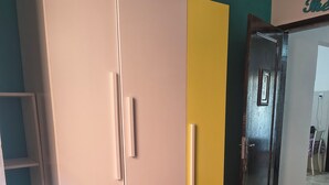 Habitació amb un armari gran, una porta de fusta i un sòl de rajola.