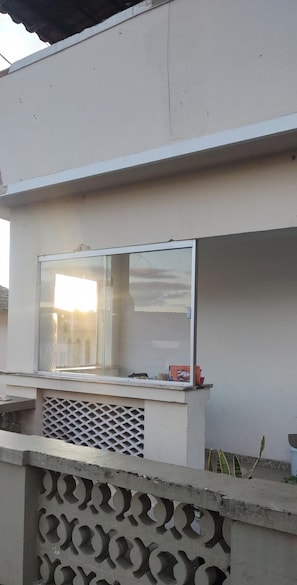 A building with a large window reflecting a building and sky.