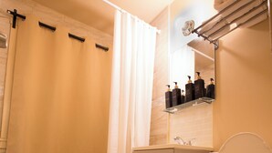Une salle de bain avec une baignoire, des toilettes et une étagère contenant des articles de toilette.