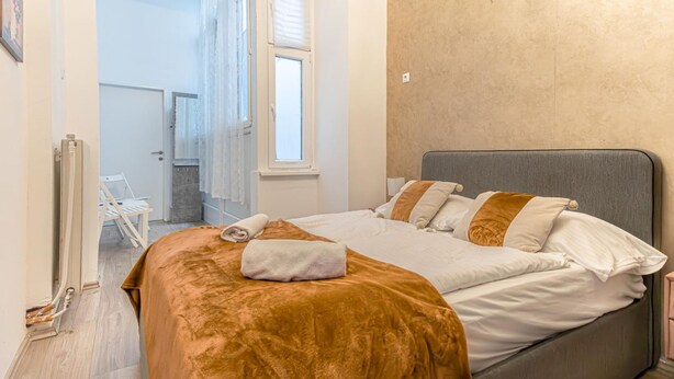 Un dormitorio con una cama, una ventana y una puerta que da a un baño.