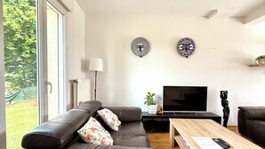 A modern living room with a leather sofa, a wooden coffee table, and a TV. - Zen House Clervaux Castle at 10 min (Clervaux)