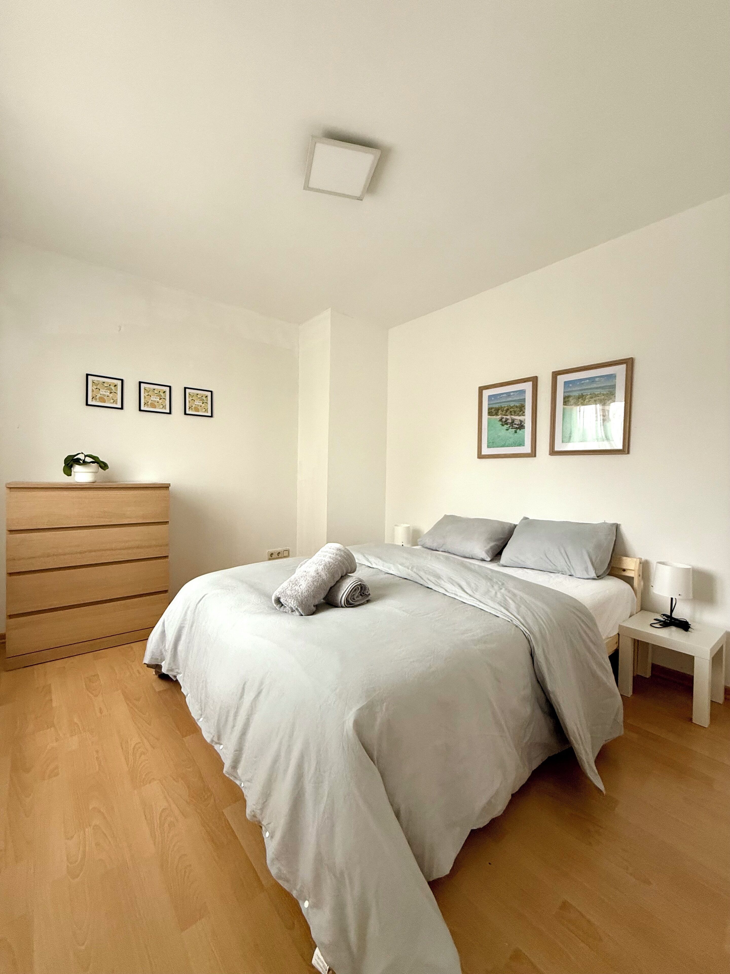 A bedroom with a bed, a dresser, and two bedside tables.