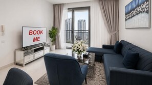 A modern living room with a sofa, a coffee table, a TV, and a plant.