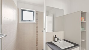 A modern bathroom with a shower, a sink, and a mirror. - The Palm House in Cowes (Cowes)