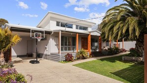 A modern two-story house with a covered porch, a basketball hoop, and a well-maintained lawn. - The Palm House in Cowes (Cowes)