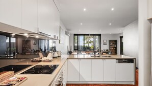 Una cucina moderna con isola centrale, elettrodomestici integrati e zona pranzo con vista.