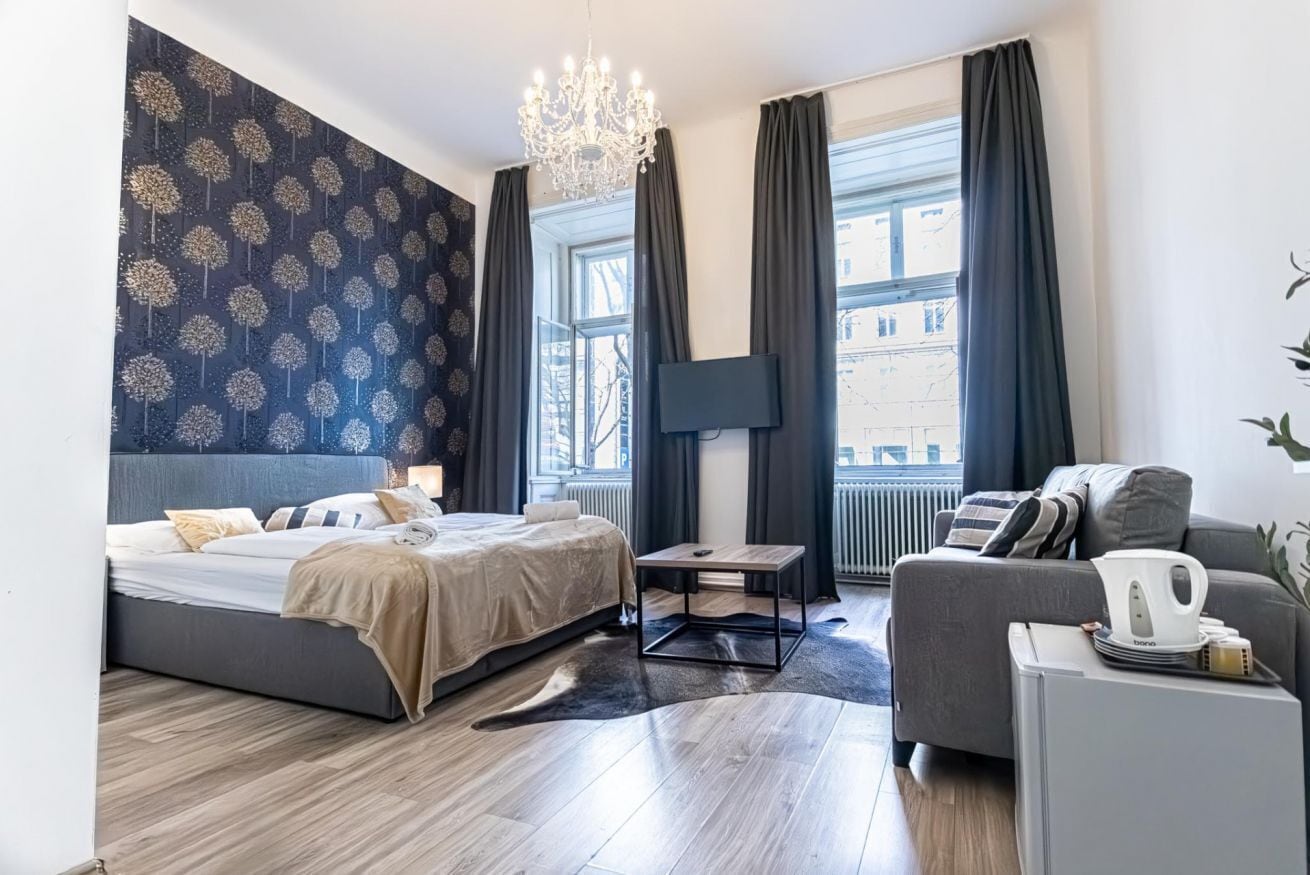 Une chambre d’hôtel moderne, dotée d’un grand lit, d’un canapé, d’une table basse et d’un téléviseur.