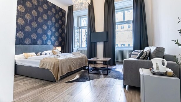 Une chambre d’hôtel moderne, dotée d’un grand lit, d’un canapé, d’une table basse et d’un téléviseur.