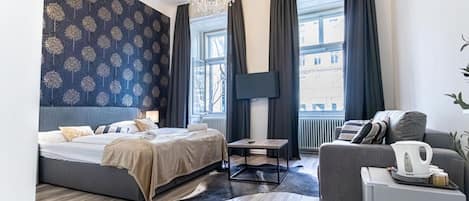 Une chambre d’hôtel moderne, dotée d’un grand lit, d’un canapé, d’une table basse et d’un téléviseur.