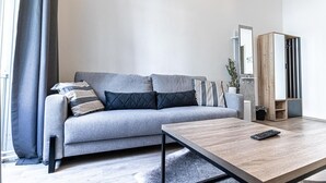 Un salon moderne avec un canapé gris, une table basse en bois et un meuble encastré en bois.