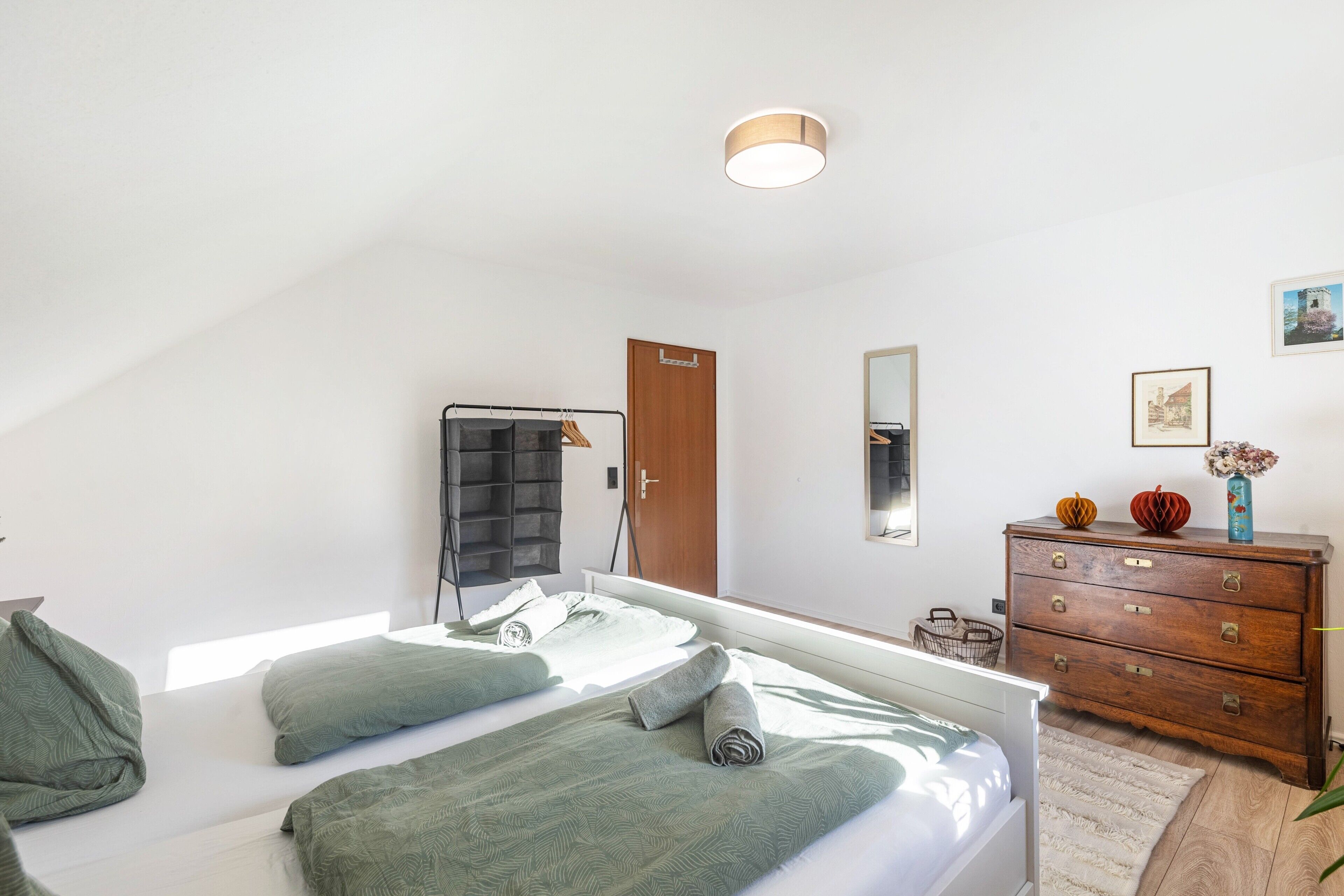Ein Schlafzimmer mit einem Bett, einem Schminktisch, einem Spiegel und einer Tür.