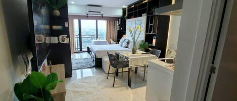 Une chambre d’hôtel moderne dotée d’un lit, d’un coin repas et offrant une vue sur la ville.