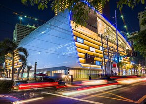 A modern building with a curved glass facade, multiple floors, and a prominent sign for 'Ritz-Carlton.' - Incredible Makati Studio Unit/Stunning view &70"TV (Makati)