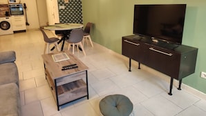 A living room with a TV, sofa, coffee table, and dining area. - AIMARGUES HOUSE 20 MN FROM THE SEA IDEAL FOR VACATIONS OR BUSINESS TRIPS (Aimargues)