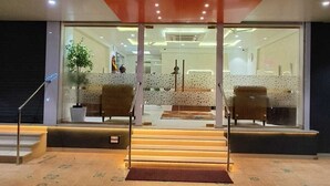 Het uiterlijk van Hotel Pritam met een modern ontwerp, met een glazen entree en een zichtbare receptie binnen.