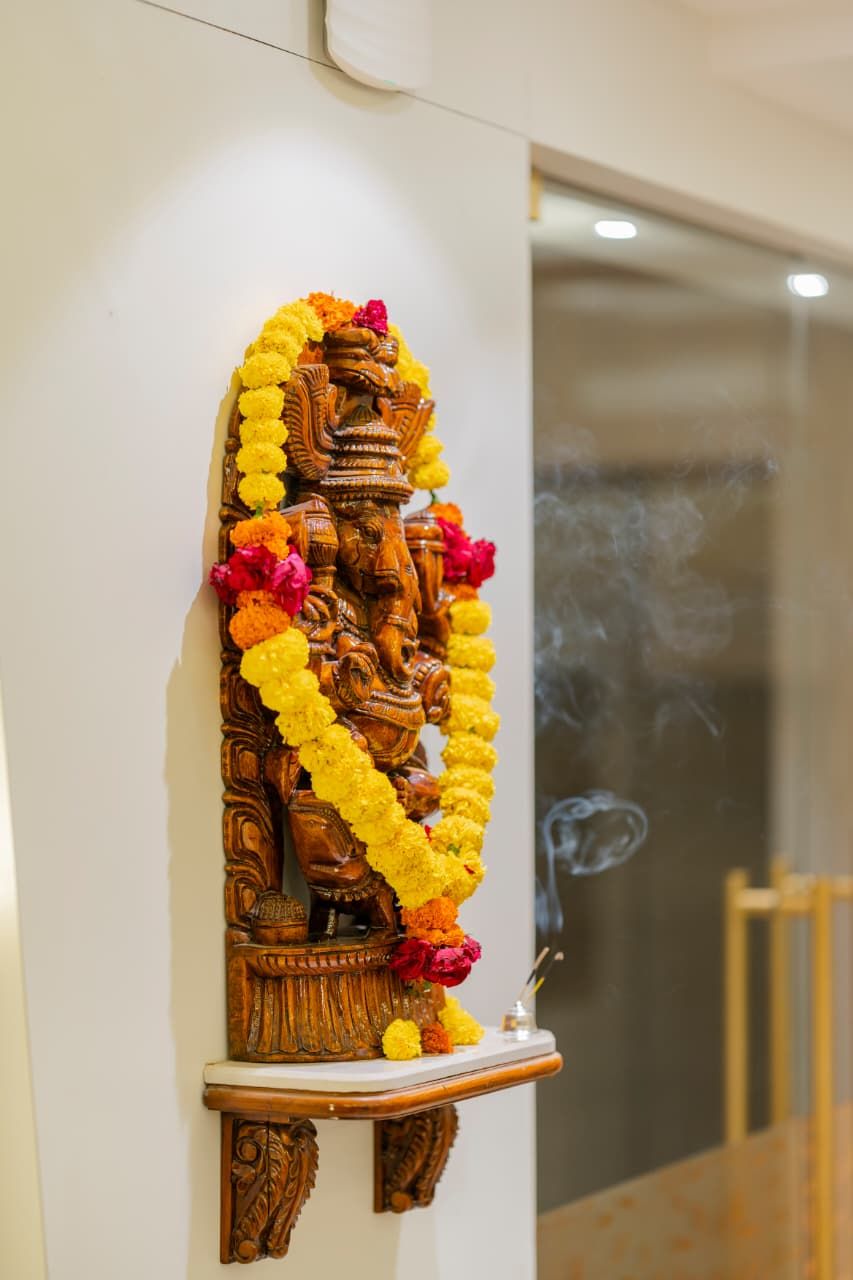 Una escultura de madera adornada con una guirnalda de flores.