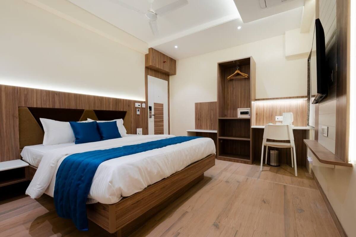 Een moderne hotelkamer met een groot bed, nachtkastjes, een bureau en een kledingkast.