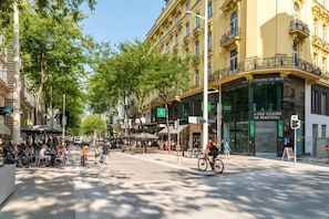 A street with a café, a restaurant, and a store with a sign reading 'Limited Colors of Benetton.'