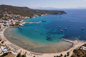 A coastal town with a beach, boats, and a pier.