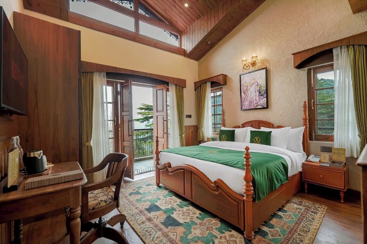 Un dormitorio amplio con una cama grande, muebles de madera y un balcón con cortinas.