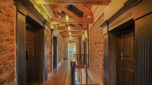 A hallway with wooden floors and stone walls, leading to a staircase. - BluSalzz Terrah Hills Resort, Dalhousie-Member of SLH Hilton Hotels (Dalhousie)