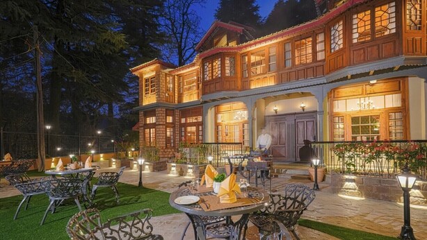 An outdoor dining area with tables and chairs, a chef preparing food, and a building with large windows and a balcony. - BluSalzz Terrah Hills Resort, Dalhousie-Member of SLH Hilton Hotels (Dalhousie)