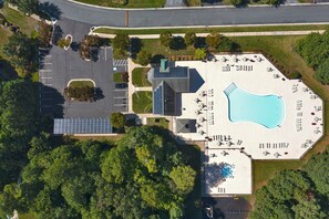Vista aérea de un hotel con piscina, aparcamiento y paneles solares.