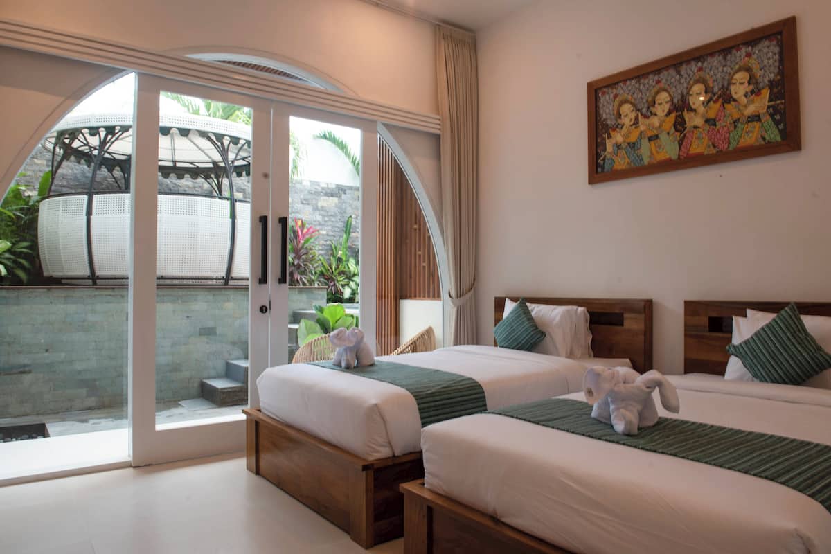 Una habitación de hotel con dos camas, un ventanal grande y un cuadro en la pared.