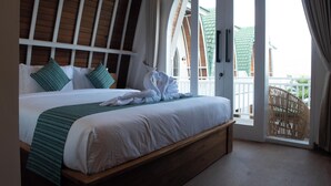 Une chambre avec un grand lit, une tête de lit en bois et une vue sur le balcon extérieur.