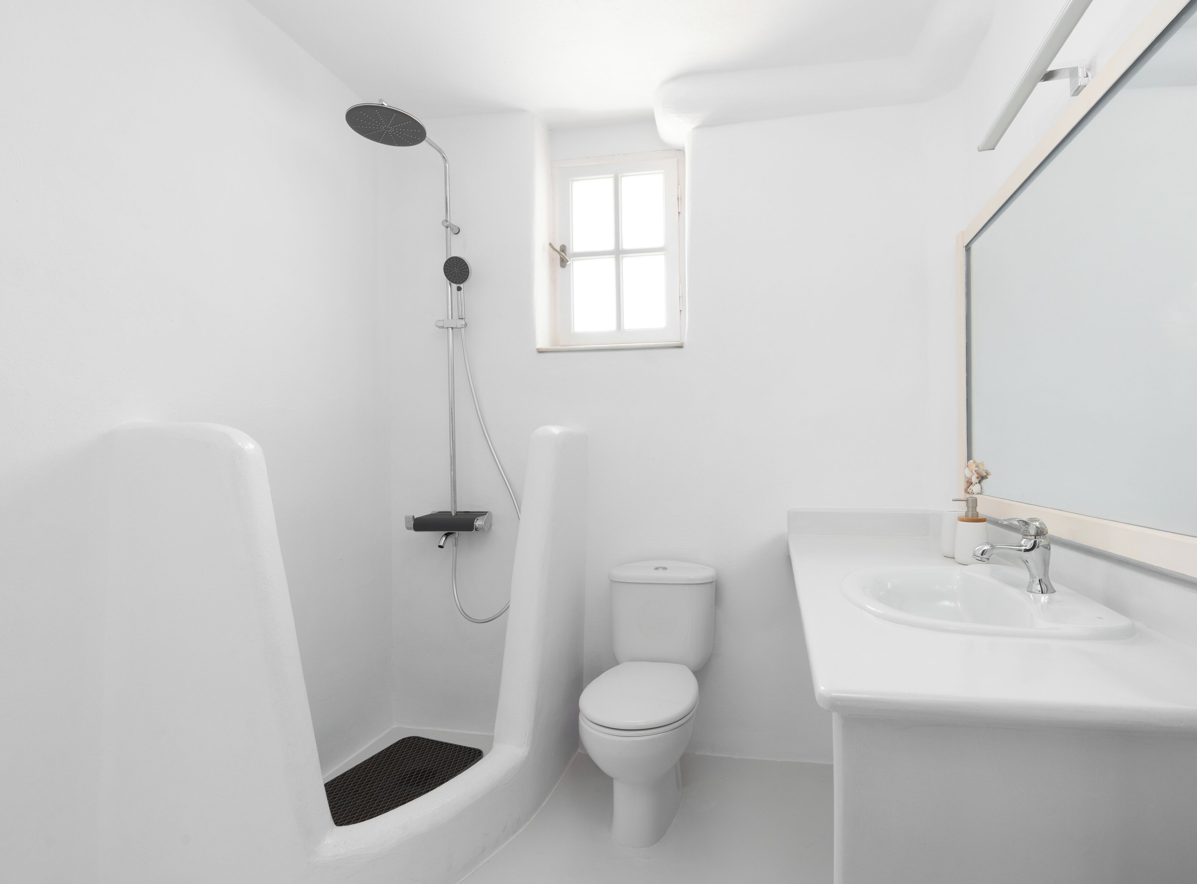 A modern bathroom with a walk-in shower, toilet, and sink.