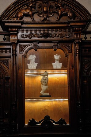 Un meuble en bois orné de sculptures complexes et doté d’un miroir.