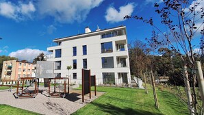 Un immeuble d’appartements moderne doté de nombreux balcons et d’un jardin bien entretenu.