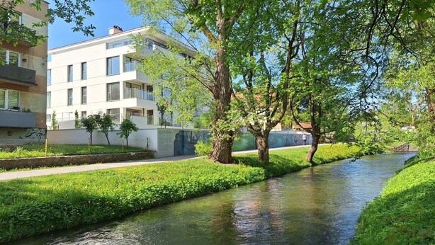Un quartier résidentiel caractérisé par un étroit canal, de nombreux espaces verts et des immeubles d’appartements modernes.