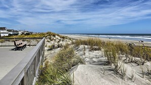 Eine Promenade mit Bänken mit Blick auf Strand und Meer.