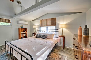 A bedroom with a bed, bedside tables, a bookshelf, a dresser, and a window with blinds. - 'poplar Cottage' Minutes to Stone Harbor Beaches! (Cape May Court House)