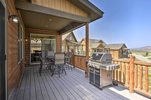 A wooden deck with a grill, chairs, and a table. - Deluxe Granby Ranch Hillside Home: Private Hot Tub (Granby)