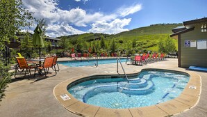 A pool area with lounge chairs and a hot tub, surrounded by a mountainous landscape. - Deluxe Granby Ranch Hillside Home: Private Hot Tub (Granby)