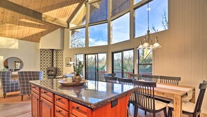 A spacious kitchen with a large island, wooden cabinets, and a dining area with a table and chairs.