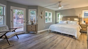 A bedroom with a large bed, a chair, a nightstand, and a ceiling fan.
