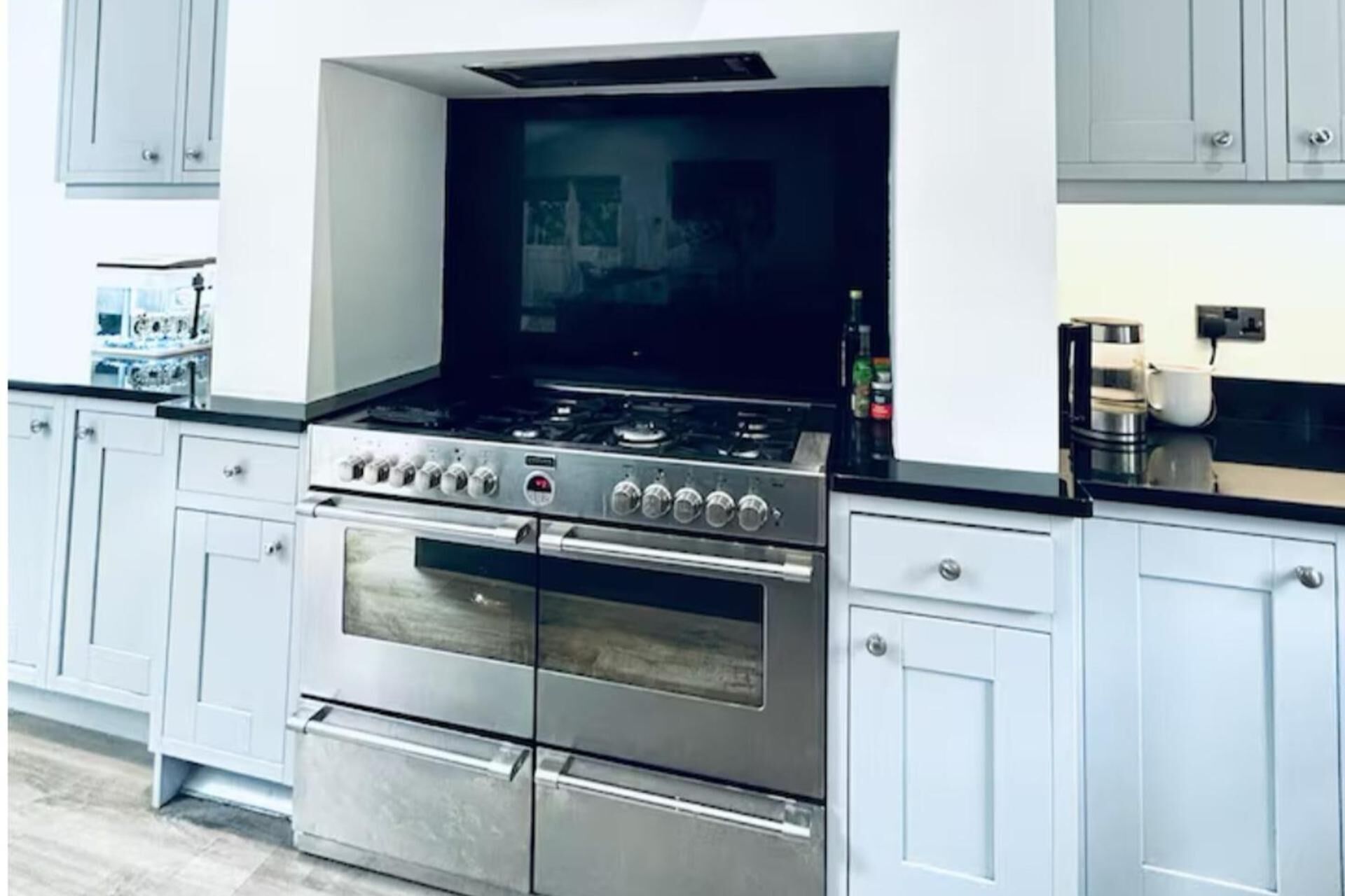 Een keuken met een roestvrijstalen fornuis, oven en een ingebouwde magnetron.