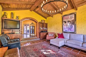 A cozy living room with a fireplace, leather furniture, and a large rug.