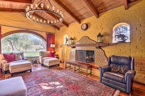 A cozy living room with a fireplace, leather armchair, and two sofas.