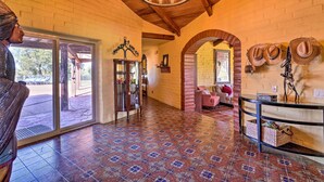 A spacious lobby with a patterned tile floor, a wooden ceiling, and a glass door leading outside.