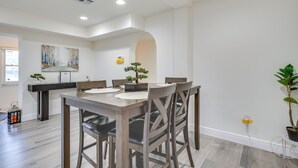 A dining area with a wooden table and chairs, a small potted plant, and a painting on the wall. - Easy Intl Soccer Stay < 3 Mi to Hard Rock Stadium (Miami Gardens)
