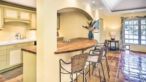 A kitchen with a wooden island, bar stools, and a window with a view. - Bright St Thomas Getaway W/pool, 3Mi to Magens Bay (St. Thomas)