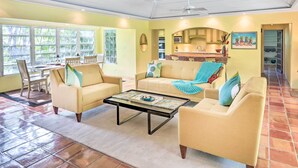 A spacious living room with a large window, a dining area, and a kitchen visible through an archway. - Bright St Thomas Getaway W/pool, 3Mi to Magens Bay (St. Thomas)