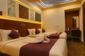 A hotel room with two beds, a desk, and a mirror. - Hotel Maitreya Inn (Vellore)