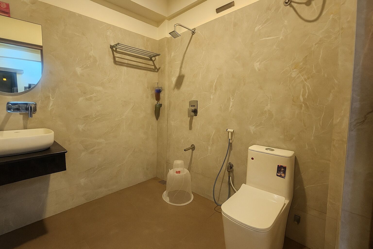 Une salle de bain équipée d’un lavabo, de toilettes, d’une douche et d’un porte-serviettes.
