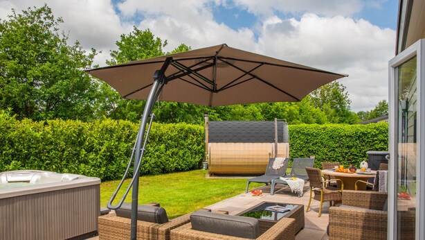 A patio area with outdoor furniture, a hot tub, and a large umbrella.